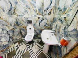 a bathroom with a toilet and a sink in it at Executives palace in Rāmgarh +9 photos