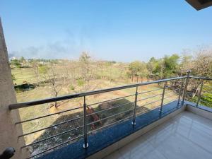 a balcony with a view of a cow on a field at Executives palace in Rāmgarh