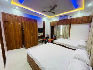 a hotel room with two beds and a blue ceiling at Executives palace in Rāmgarh