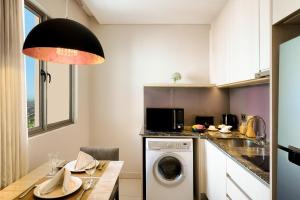 a kitchen with a washer and dryer in a room at Ascott Waterplace Surabaya in Surabaya