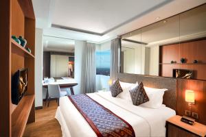 a hotel room with a large bed with a large mirror at Ascott Waterplace Surabaya in Surabaya