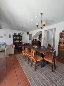 a living room with a wooden table and chairs at Casa dos Pocinhos - Férias tranquilas no campo in Torres Novas
