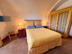 a bedroom with a bed and two lamps and a chair at Exclusive Villa - Relax - A-C - Stunning View in Porto Ercole