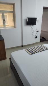 a white bed in a room with avertisement at Krisna vykundam in Guruvāyūr