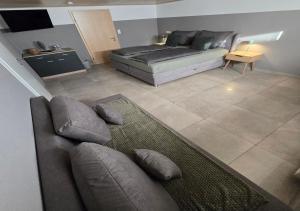 a living room with a couch and a bed at Gästehaus Alwin Diebold - 5 Gehminuten zum Europapark in Rust