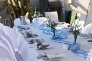 a long table with blue plates and napkins and flowers at sul mare סוויטות in Ashkelon +70 photos