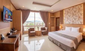 a hotel room with a bed and a large window at Lien Do Star Hotel in Bảo Lộc