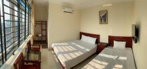 a small room with two beds and a window at Khách sạn Tâm An in Ða Gia
