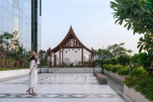 a woman standing in front of a building at SZ Canalside Hotel in Bangkok