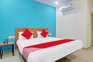 a bedroom with a large bed with red pillows at Hotel O Langar Houz Near Golconda Fort in Hyderabad