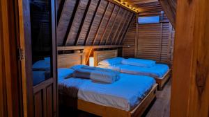 a room with two beds in a wooden cabin at Villa de Gema in Selabintana