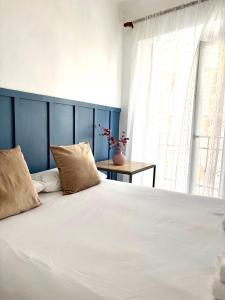 a large white bed with two pillows and a window at CASA VERA, Casa completa para familias o grupos en el centro de Antequera in Antequera
