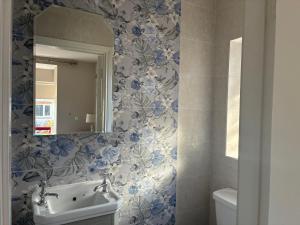 a bathroom with blue and white flowers on the wall at Arden Bungalow in Baltray +38 photos