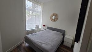 a white bedroom with a bed and a window at Perfectly Located, Surprisingly Quiet in Gouda