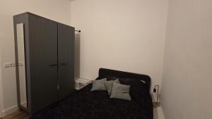 a bedroom with a black bed and a cabinet at Perfectly Located, Surprisingly Quiet in Gouda