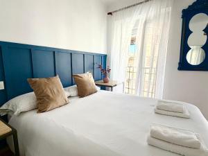 a bedroom with a large bed with two pillows at CASA VERA, Casa completa para familias o grupos en el centro de Antequera in Antequera