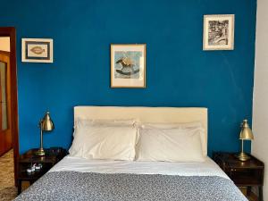 a bedroom with a blue wall and a bed at RioRooms La Valletta Riomaggiore Center in Riomaggiore +18 photos