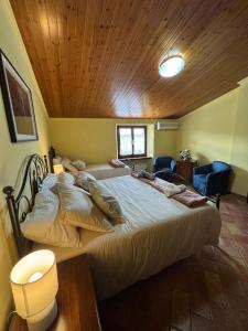 a large bed in a room with a wooden ceiling at Locanda del Castello in Frontone