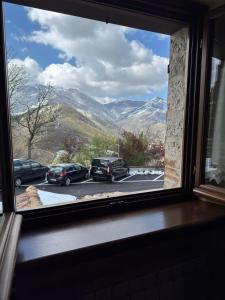 a window with cars parked in a parking lot at Locanda del Castello in Frontone