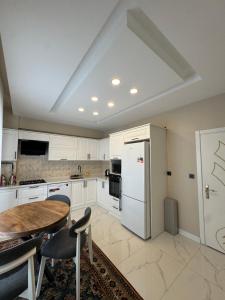 a kitchen with a table and a white refrigerator at Yeşilyurt villa in Sapanca