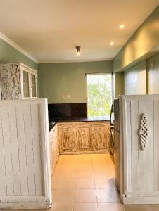 a kitchen with wooden cabinets and a refrigerator at Soma Bloom Resort in Jembrana