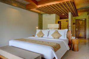 a bedroom with a large white bed in a room at Kastara Resort in Ubud