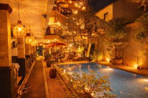 an indoor swimming pool with lights in a building at Tendan Residence in Legian