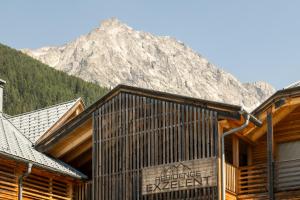 a log cabin with a mountain in the background at Mountain Exzelent Residence - Luxury Alpine Apartments in Anterselva di Mezzo