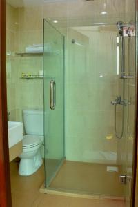 a bathroom with a toilet and a glass shower at Muarar 99 Hotel in Muar