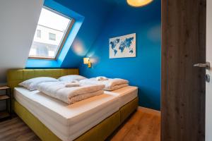 a bedroom with a bed with a blue wall at Laras Loft in Leipzig