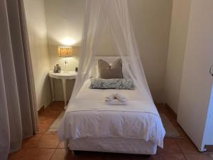 a bedroom with a bed with a canopy at Haze Inn Cottages Wattle in Henburg Park