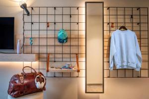 a bathroom with a mirror and a white sweater and a bag at Moxy Bordeaux in Bordeaux