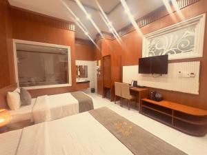 a hotel room with two beds and a desk and a television at Lien Do Star Hotel in Bảo Lộc