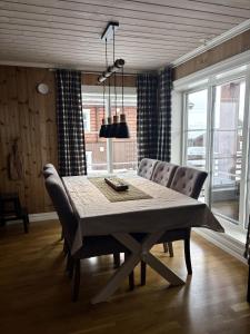 a dining room table with chairs and a table and a lamp at Lastølen Snr6 nr2 in Sykkylven