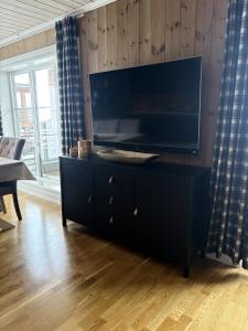 a black dresser with a large television on top of it at Lastølen Snr6 nr2 in Sykkylven