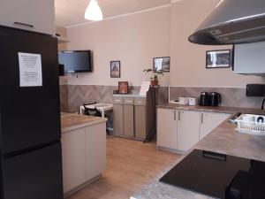 a kitchen with white cabinets and a black refrigerator at Rynek 7 in Katowice