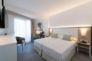 a hotel room with a bed and a desk at Medplaya Hotel Regente in Benidorm +25 photos