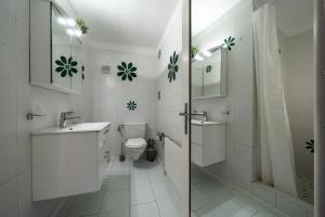 a white bathroom with a toilet and a sink at Alpine view with balcony near Interlaken in Wilderswil