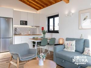 a living room with a blue couch and a kitchen at Bird House by PontaNegraAzores in Altares