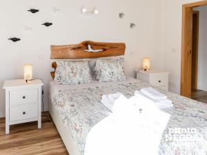 a bedroom with a large bed with two night stands at Bird House by PontaNegraAzores in Altares