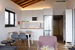 a kitchen with a table and chairs and a refrigerator at Photography House by PontaNegraAzores in Altares