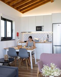 a woman sitting at a table in a kitchen at Photography House by PontaNegraAzores in Altares +9 photos