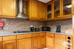 a kitchen with wooden cabinets and a stove top oven at Casa Martins by PontaNegraAzores in Biscoitos +19 photos