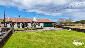 a house with a lawn in front of it at Casa das Vaquinhas by Ponta Negra Azores in Altares