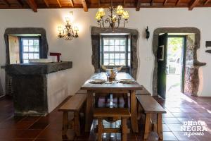 a dining room with a table and a chandelier at Casa das Vaquinhas by Ponta Negra Azores in Altares
