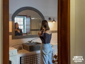 a woman taking a picture of herself in a bathroom mirror at Casa das Vaquinhas by Ponta Negra Azores in Altares