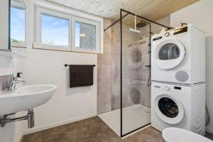a bathroom with a washing machine and a sink at FENUS SGT01 moderne Ferienwohnung in Grabs