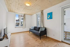 a living room with a couch and two windows at FENUS SGT01 moderne Ferienwohnung in Grabs