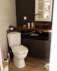 a bathroom with a white toilet and a sink at Alojamento Ponta Negra in Biscoitos +45 photos