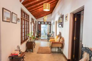 a hallway with a couch and chairs in a house at Colonial Residence Kandy Boutique Bungalow in Kandy